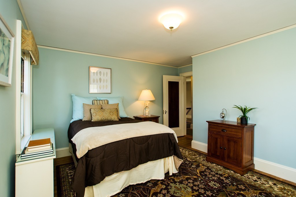 23 Virginia Road Waltham, MA 02453 - Photo 10 of 18 a bedroom with a bed and a lamp on the dresser