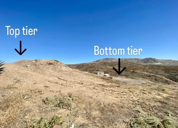 a view of a dry yard with a street sign