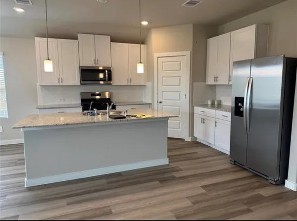 a kitchen with kitchen island white cabinets and stainless steel appliances