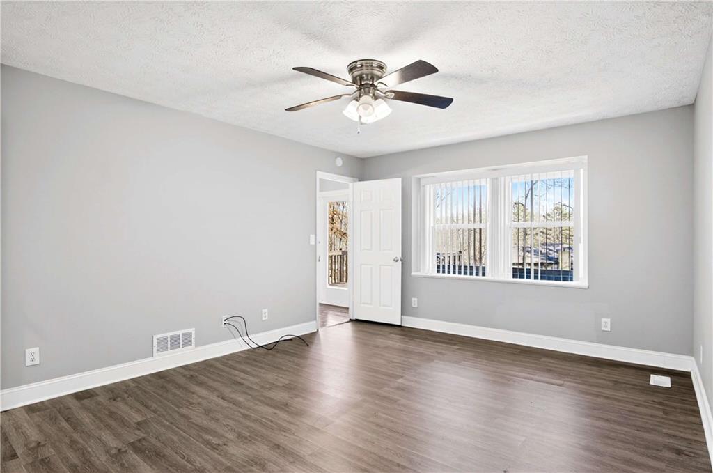 808 Emerald Chase Powder Springs, GA 30127 - Photo 12 of 32 a view of an empty room with wooden floor and a window