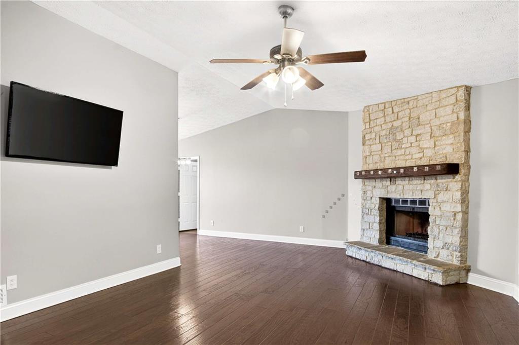 808 Emerald Chase Powder Springs, GA 30127 - Photo 4 of 32 an empty room with wooden floor fireplace and windows
