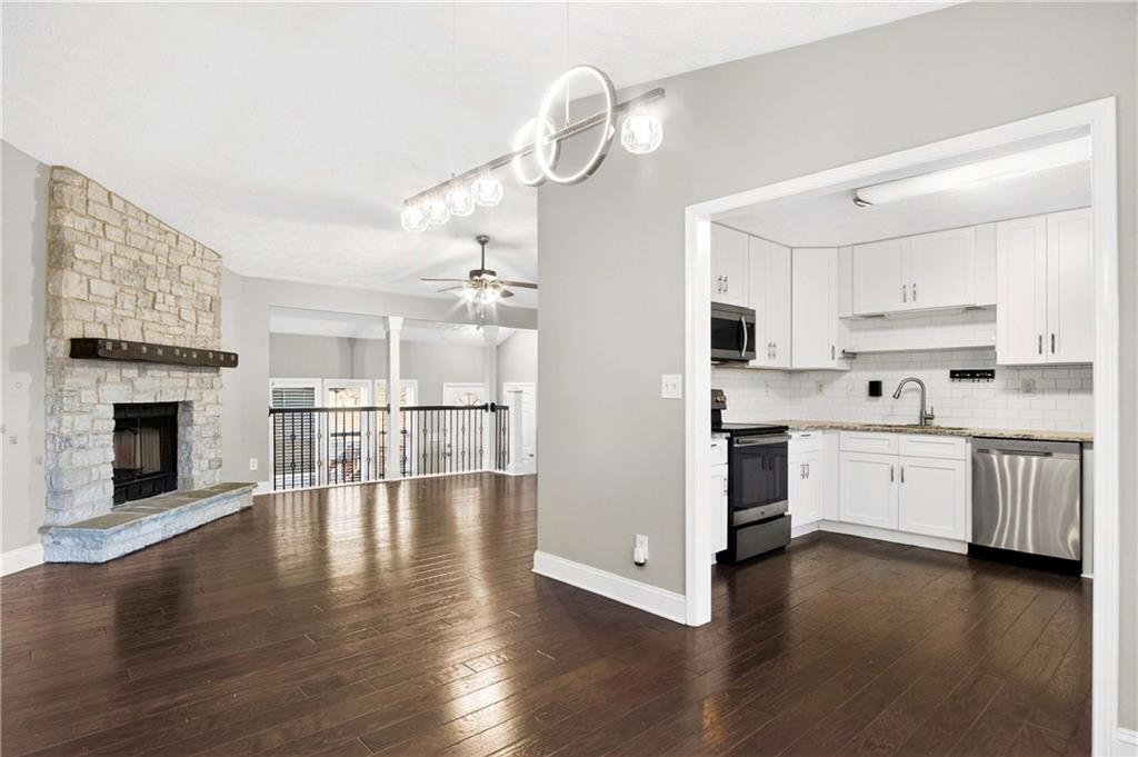 808 Emerald Chase Powder Springs, GA 30127 - Photo 7 of 32 a view of a kitchen with a sink dishwasher a fireplace and wooden floor