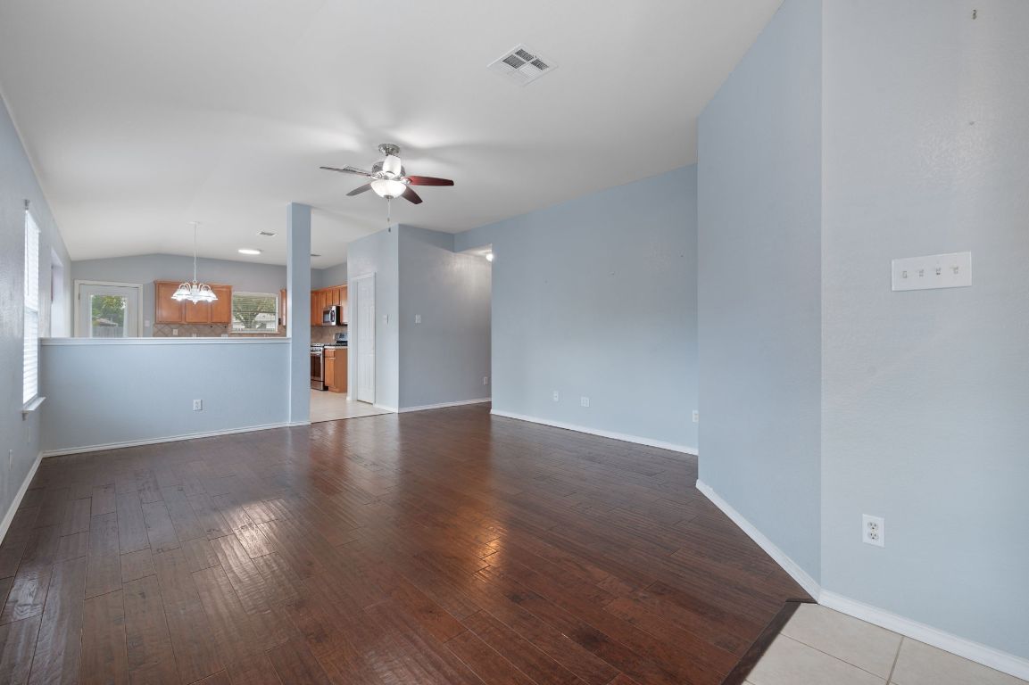 2361 Pearson Way Round Rock, TX 78665 - Photo 5 of 32 an empty room with wooden floor chandelier fan and windows
