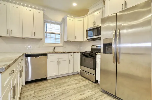 a kitchen with cabinets stainless steel appliances and a window