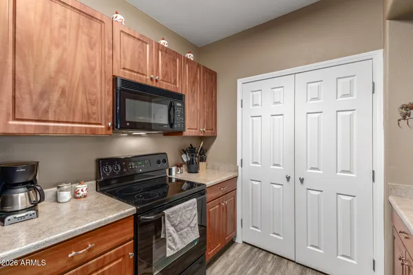 a kitchen with granite countertop a stove top oven a sink dishwasher and cabinets with wooden floor