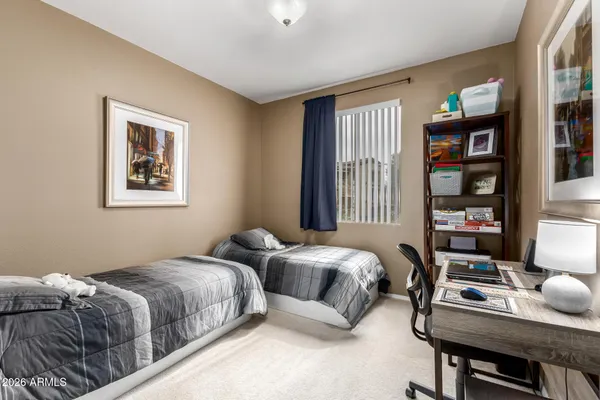 a bedroom with two beds and a desk