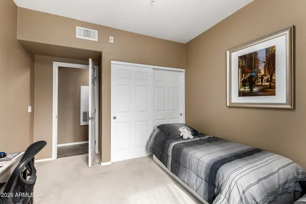 a bedroom with a bed and a painting on the wall