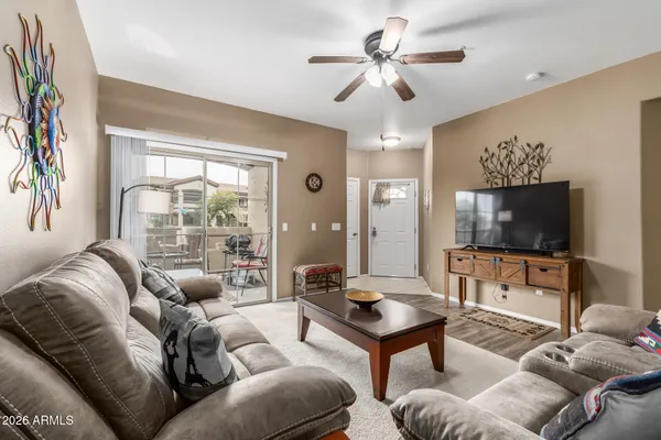 a living room with furniture a flat screen tv and a large window