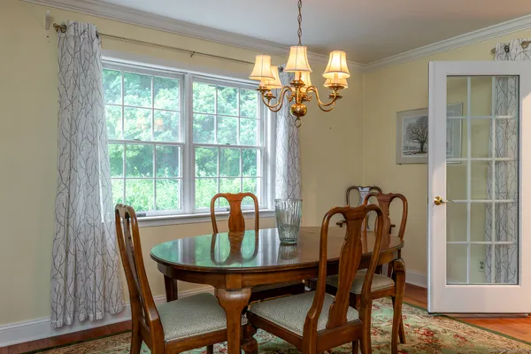 a dining room with furniture a chandelier and wooden floor