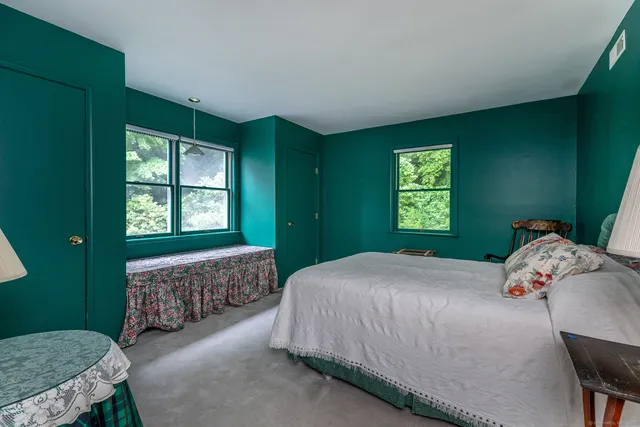 a bedroom with a bed windows and a chandelier