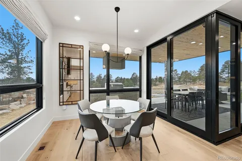 a view of a dining room with furniture large windows and wooden floor