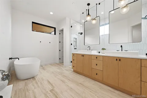 a spacious bathroom with a double vanity sink a mirror and a bathtub