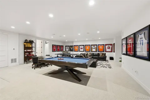a living room with furniture pool table and a flat screen tv