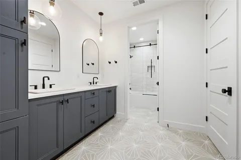 a spacious bathroom with a double vanity sink mirror and bathtub