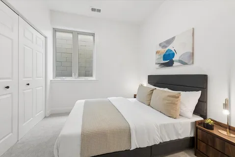 a bedroom with a bed and painting on the wall