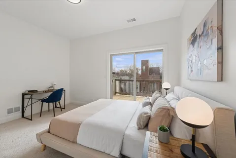 a bedroom with a bed and dresser with wooden floor