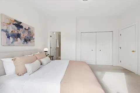 a bedroom with a bed and a painting on the wall