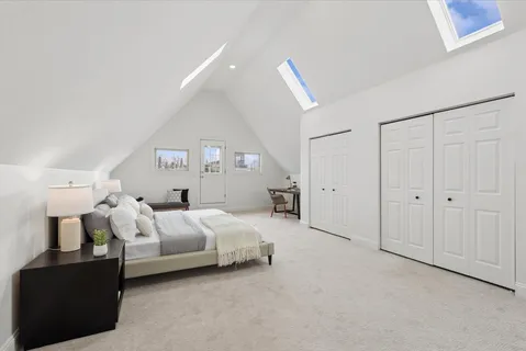 a spacious bedroom with a bed and lamp