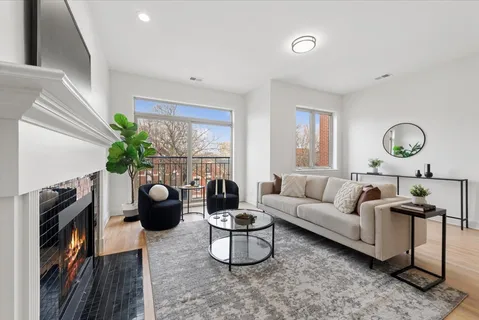 a living room with furniture a flat screen tv and a large window