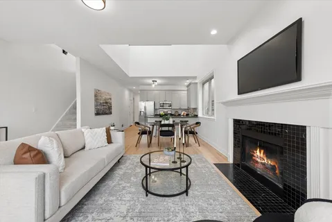 a living room with furniture a flat screen tv and a fireplace