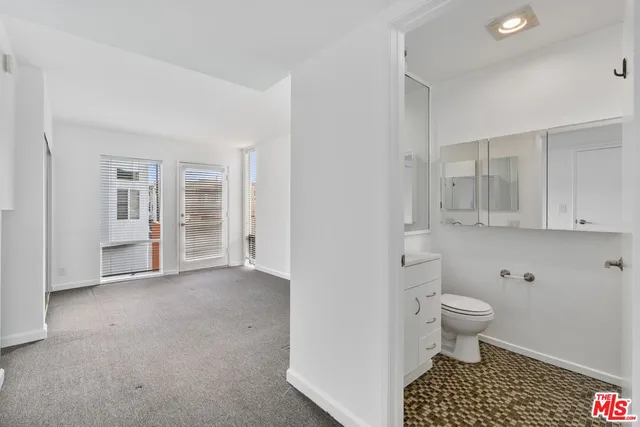 an empty room with a cabinet and mirrors