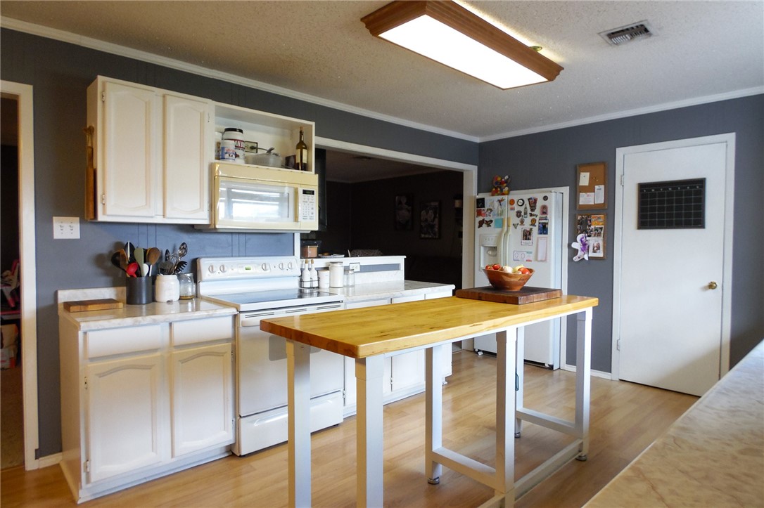 3010 North Interstate 37 Access Three Rivers, TX 78071 - Photo 28 of 29 a kitchen with stainless steel appliances granite countertop a sink a stove a refrigerator a dining table and chairs with wooden floor