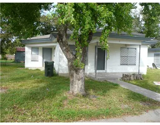 a view of a yard in front of a house with large windows