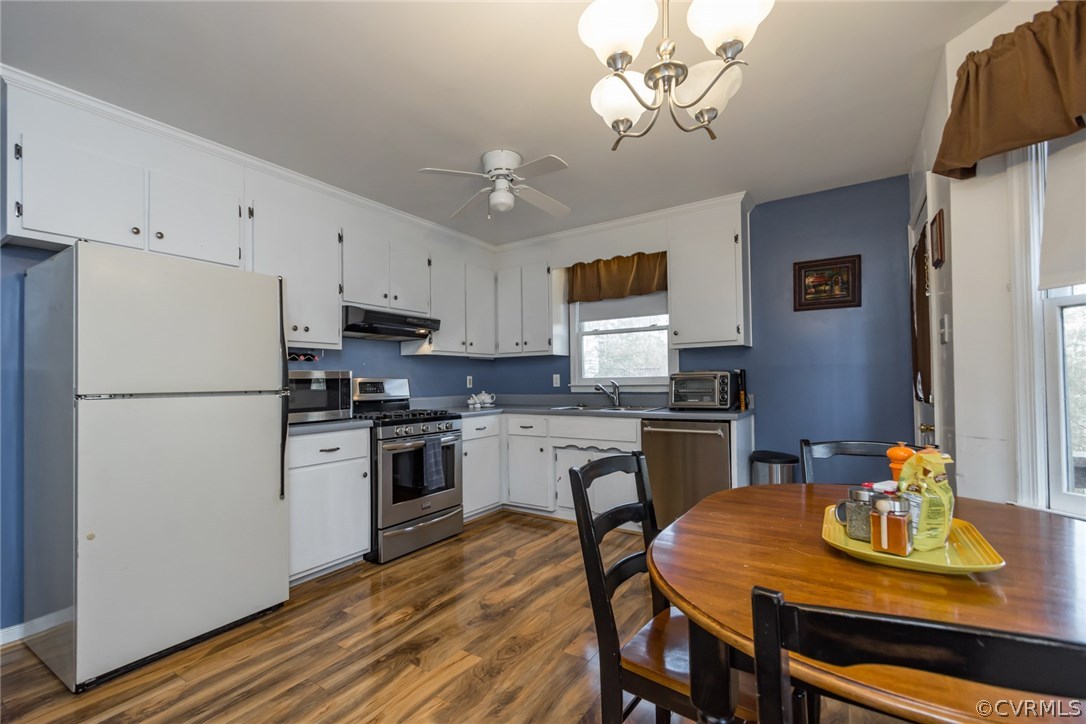 5009 Tulip Oak Road Chesterfield, VA 23832 - Photo 9 of 35 a kitchen with stainless steel appliances granite countertop a refrigerator a stove a sink dishwasher a dining table and chairs with wooden floor