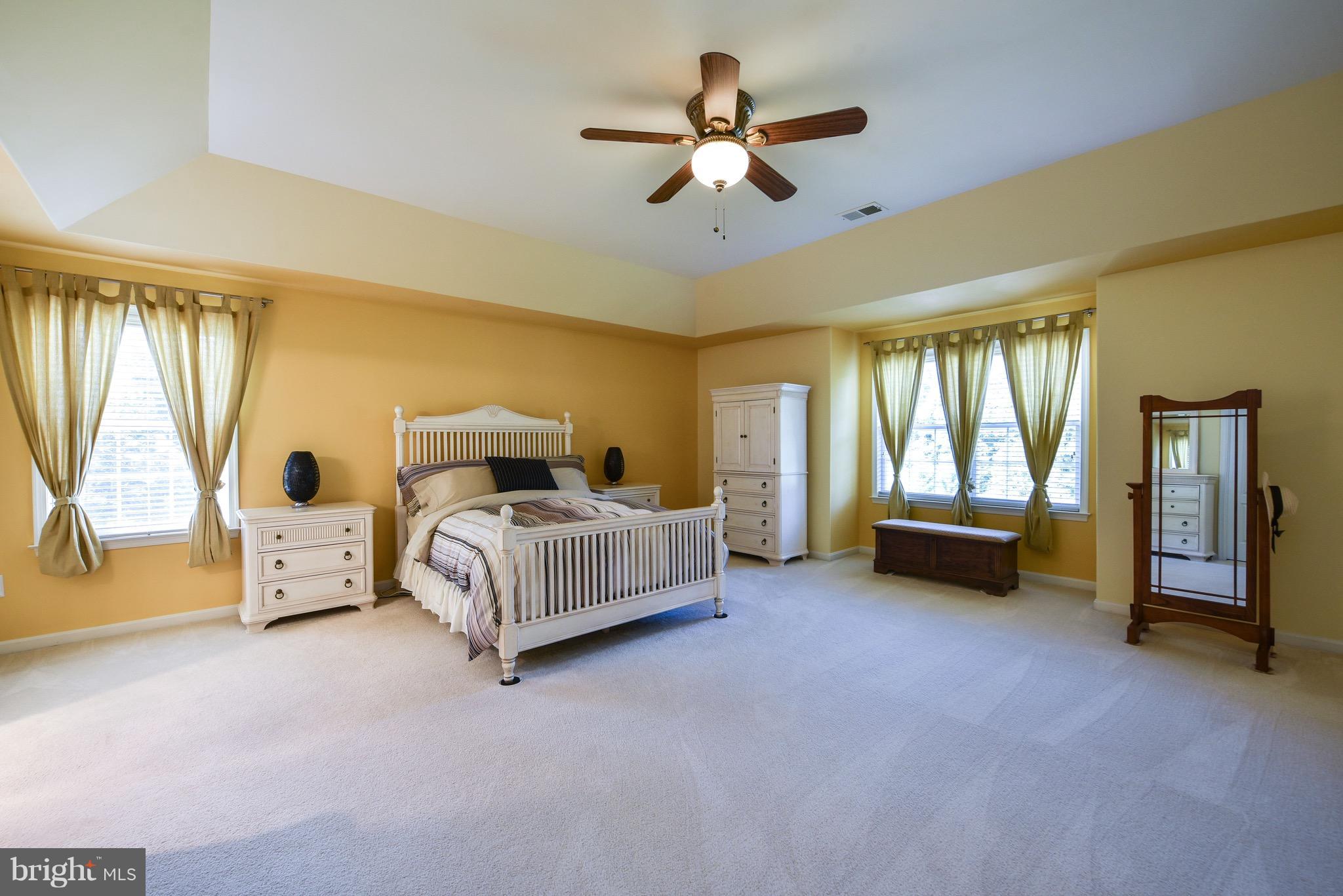 6865 North Stuart Road King George, VA 22485 - Photo 15 of 30 a spacious bedroom with a bed and a chandelier