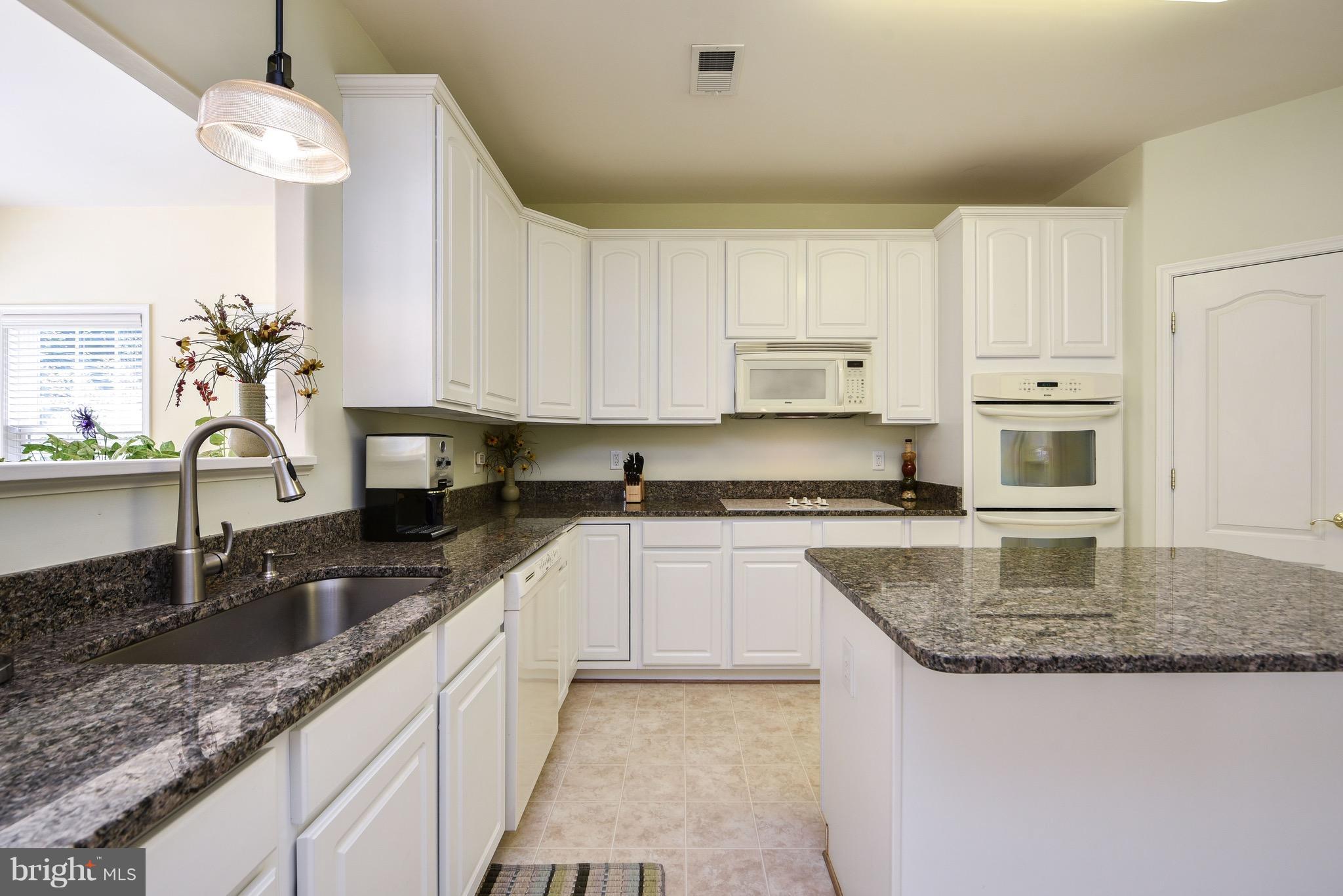 6865 North Stuart Road King George, VA 22485 - Photo 10 of 30 a kitchen with granite countertop a sink a counter top space cabinets and stainless steel appliances