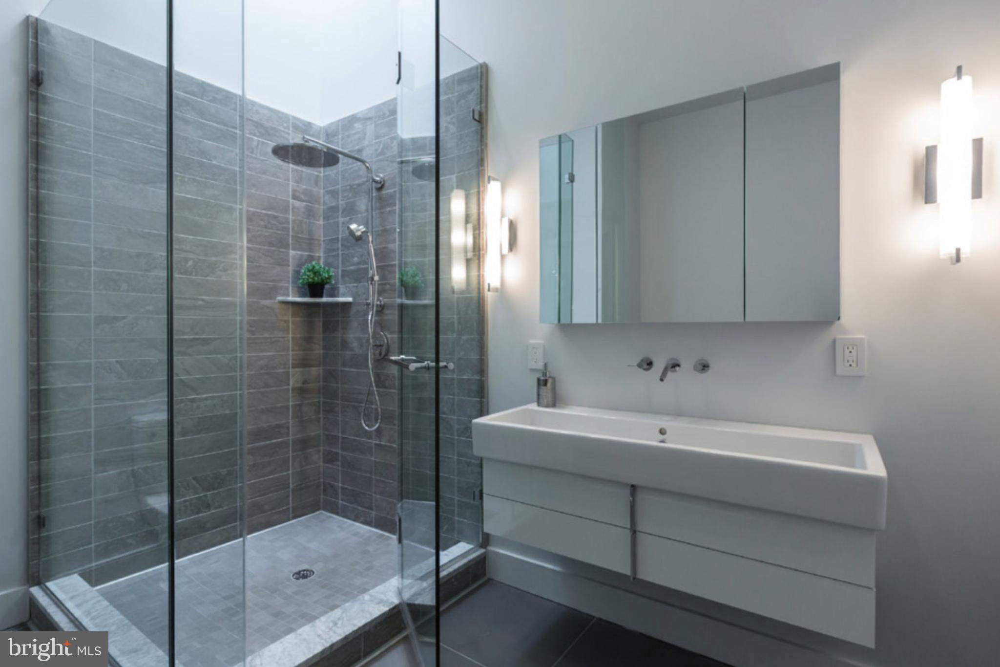 2709 N Street Northwest, Unit 102 Washington, DC 20007 - Photo 6 of 18 a bathroom with a sink a shower and a mirror