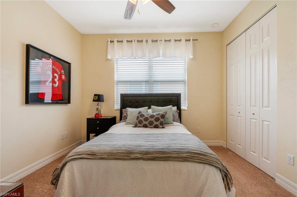 6549 Marbella Drive Naples, FL 34105 - Photo 16 of 28 a bedroom with a bed and a chandelier