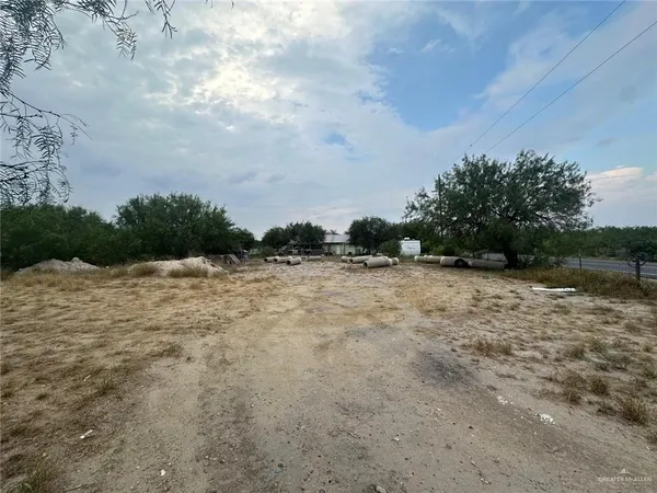 a view of a dry yard with wooden fence