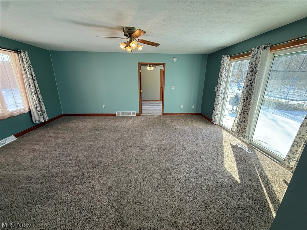 6784 Old Zoarville Road Northeast Dover, OH 44622 - Photo 15 of 50 Carpeted spare room with a ceiling fan and a textured ceiling