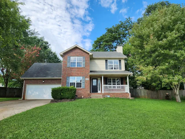 a front view of a house with yard and green space