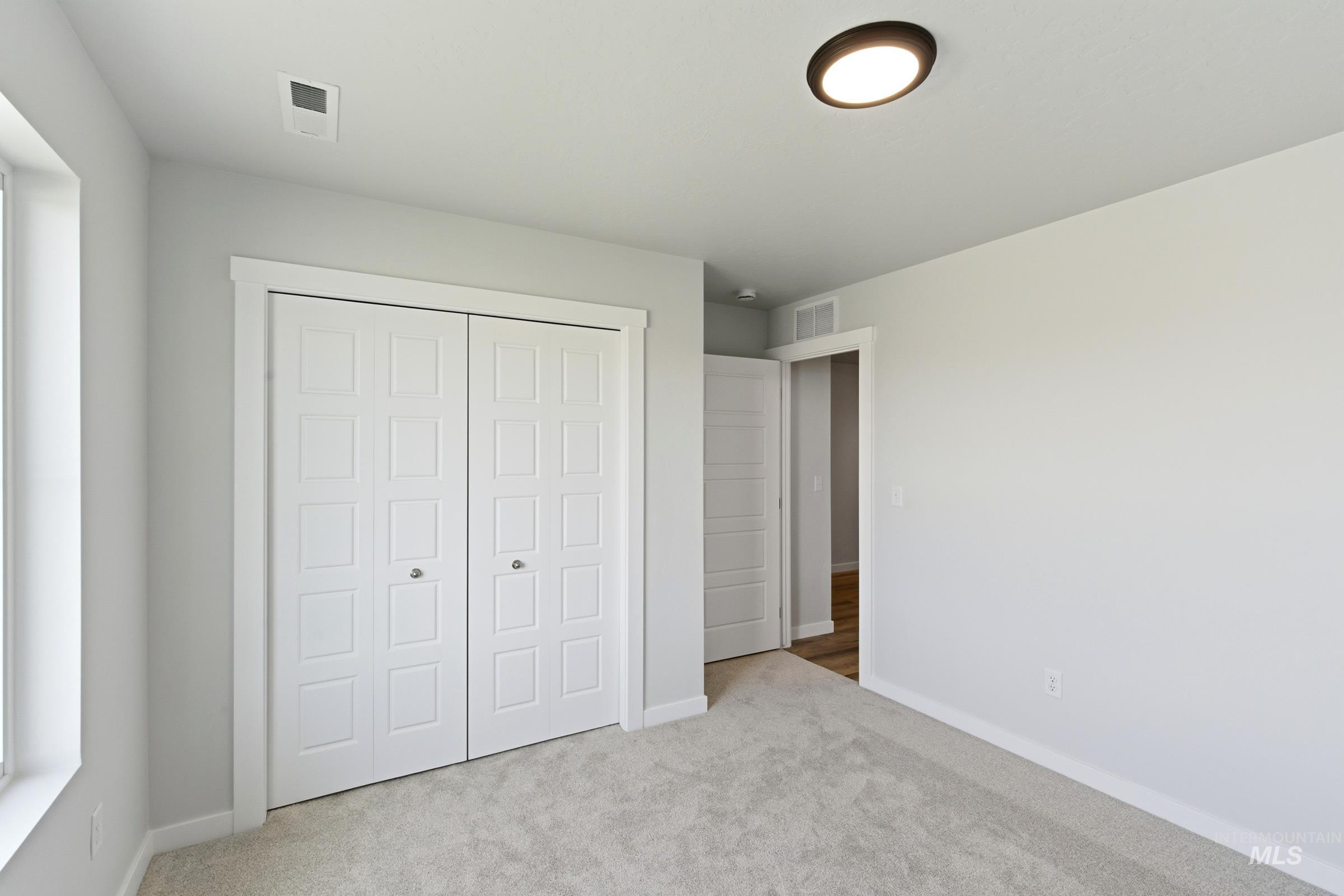8317 South Tyrion Way Kuna, ID 83634 - Photo 11 of 22 Room featuring light gray wall paint, light-colored carpet flooring, and white trim