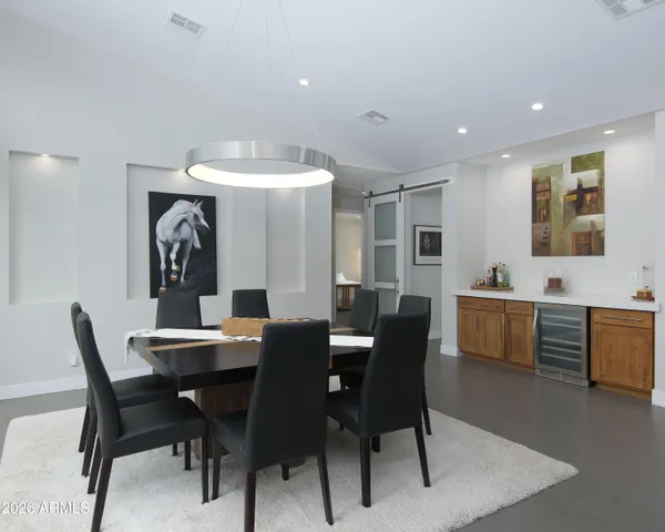 a dining room with furniture a chandelier and wooden floor