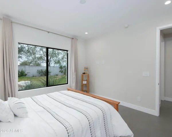 a bedroom with a bed and a large window
