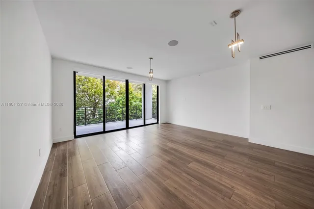a view of a room with wooden floor and windows