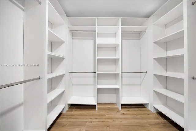a view of walk in closet with empty racks