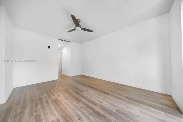 a view of empty room with wooden floor