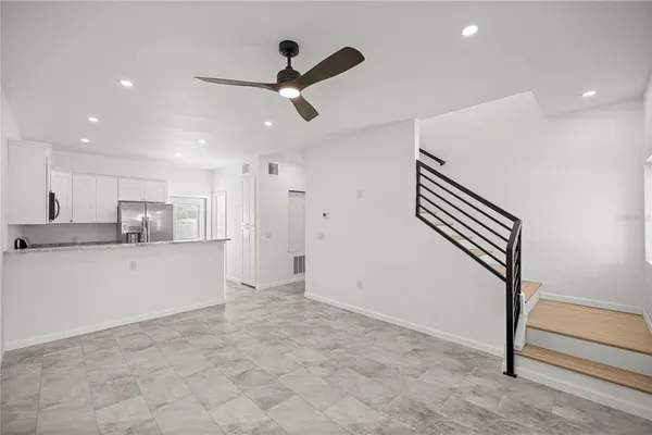 a view of kitchen with stainless steel appliances wooden floor and window