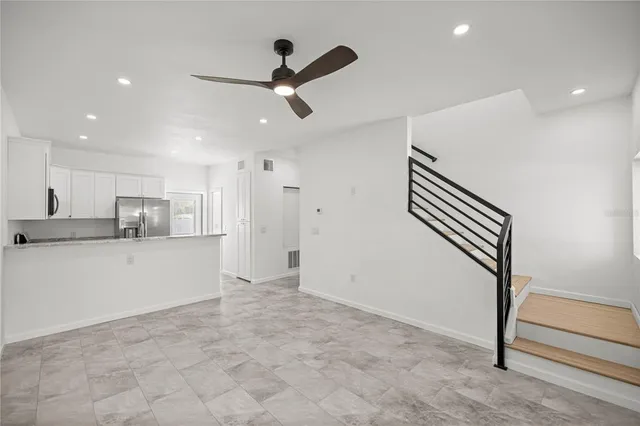 a view of kitchen with stainless steel appliances wooden floor and window