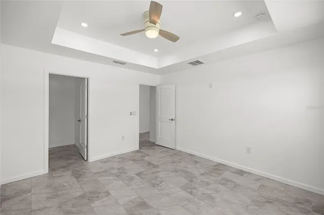 an empty room with a ceiling fan and a window