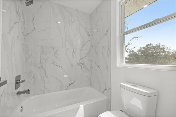 a bathroom with a toilet and a tub