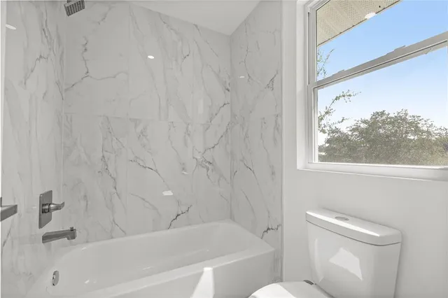 a bathroom with a toilet and a tub