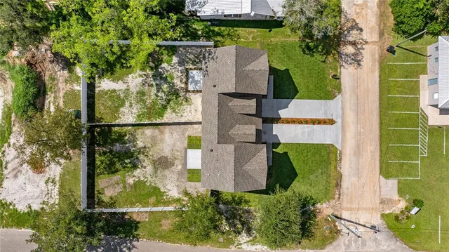 an aerial view of residential house with outdoor space and trees