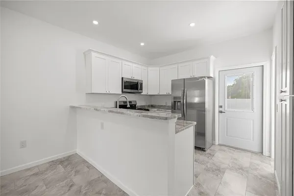 a kitchen with stainless steel appliances a refrigerator sink and microwave