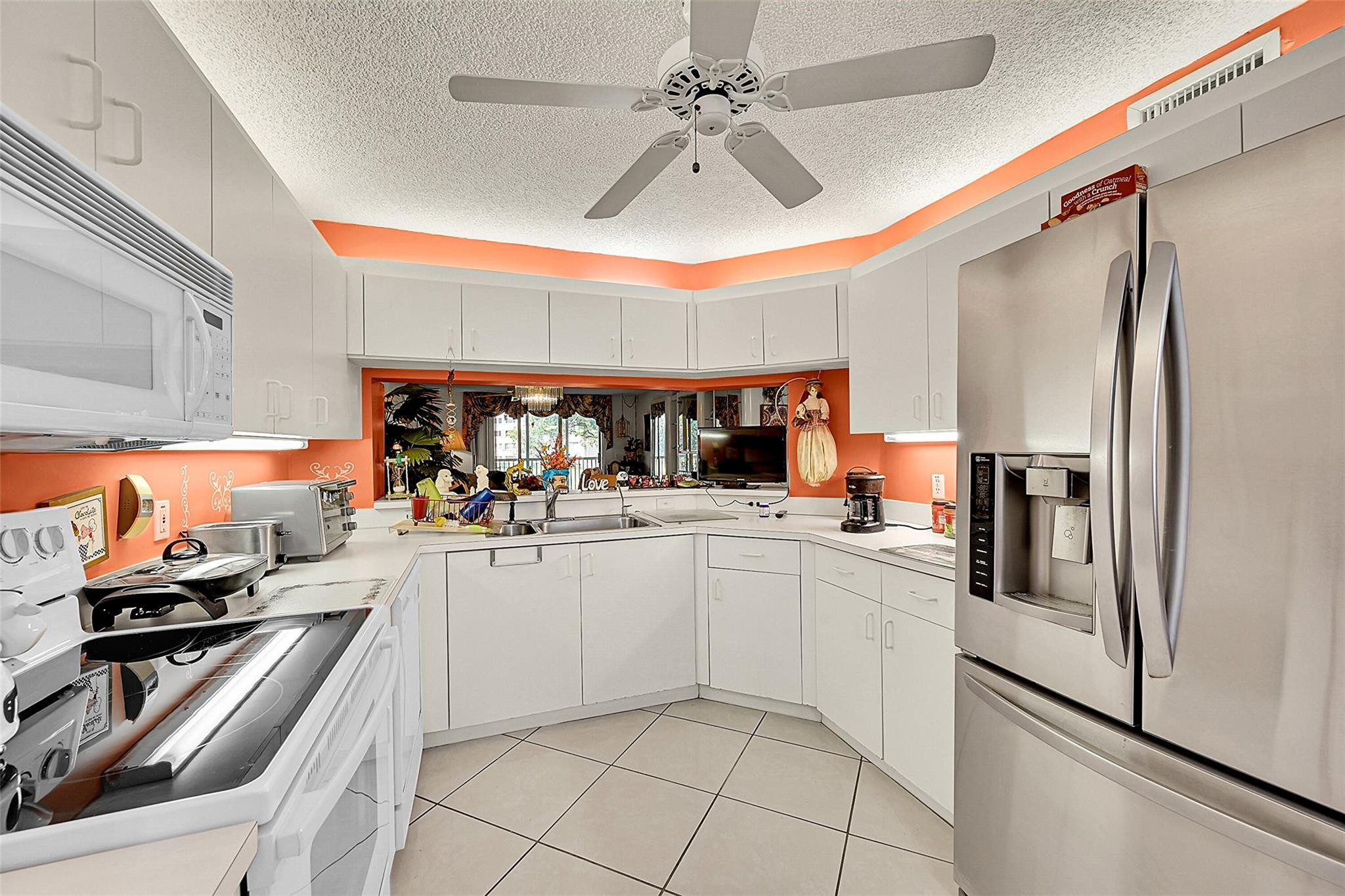 2541 North Nob Hill Road, Unit 206 Sunrise, FL 33322 - Photo 4 of 44 a kitchen with stainless steel appliances a sink and a refrigerator