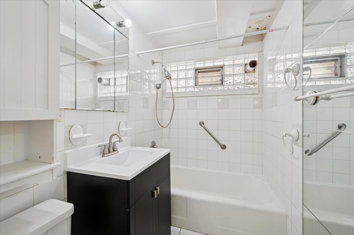 1140 West Lunt Avenue, Unit 1B Chicago, IL 60626 - Photo 12 of 13 a bathroom with a sink vanity granite tub shower and mirror